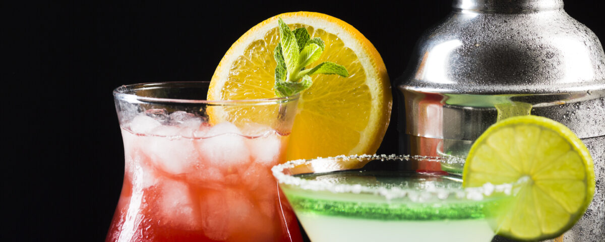 Martini shaker, N/A red drink with ice and N/A martini drink with lime green rim