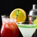 Martini shaker, N/A red drink with ice and N/A martini drink with lime green rim