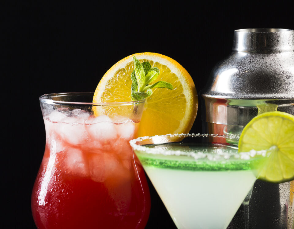 Martini shaker, N/A red drink with ice and N/A martini drink with lime green rim